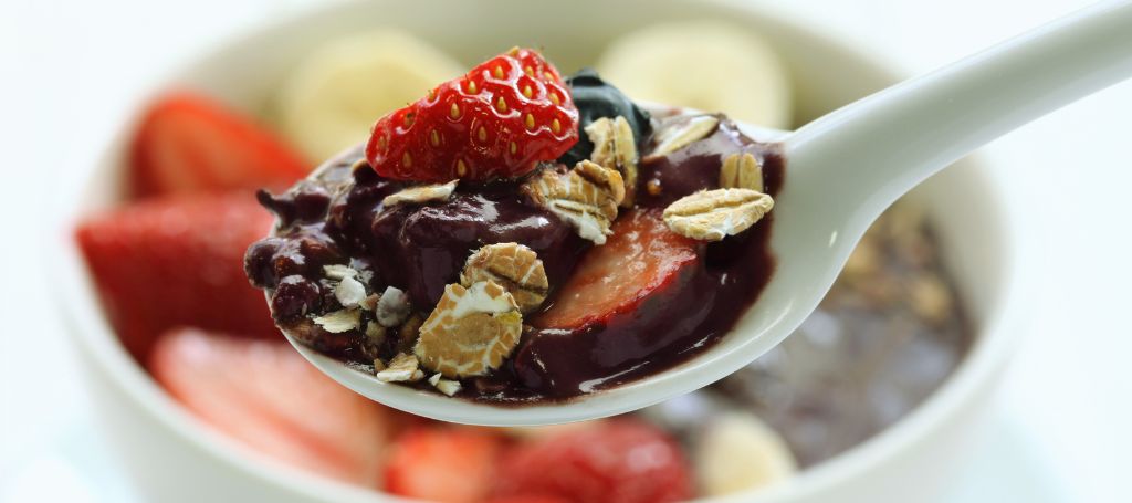 spoon with açaí, granola and strawberry