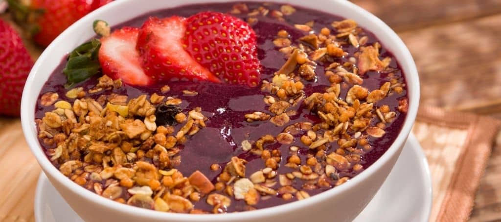 closeup photo of acai bowl with strawberries and granola