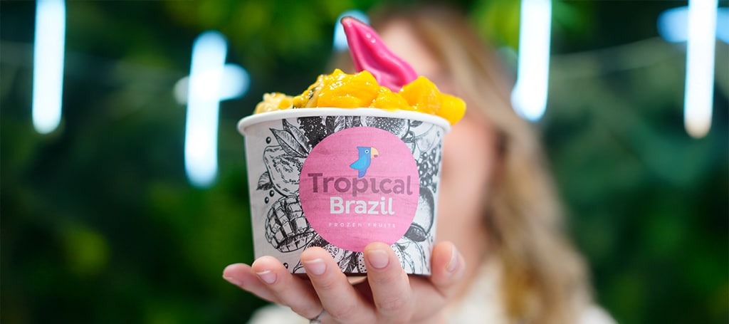close up of a woman holding an açai bowl with fruits from Tropical Brazil